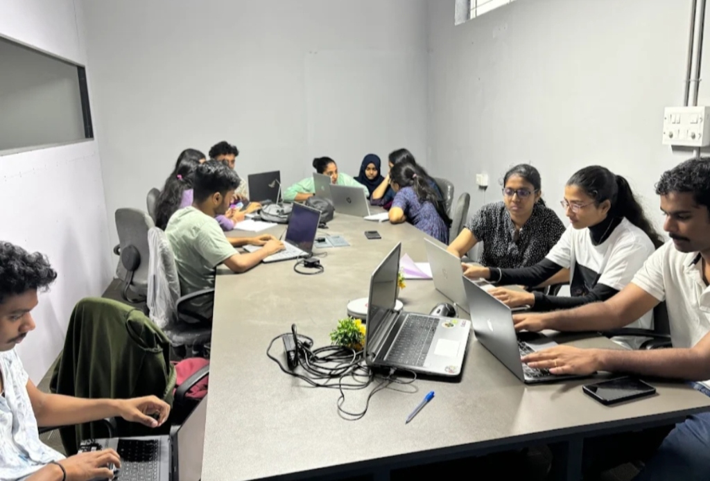 Students discussing and working on laptops in the lab