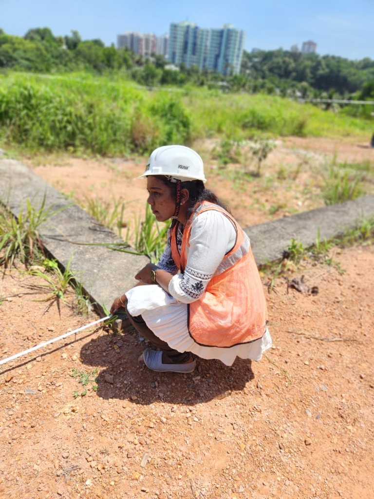 Student measuring ground boundary with tape during survey training