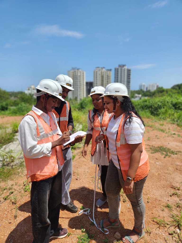 Students holding measuring tape and taking notes during field session
