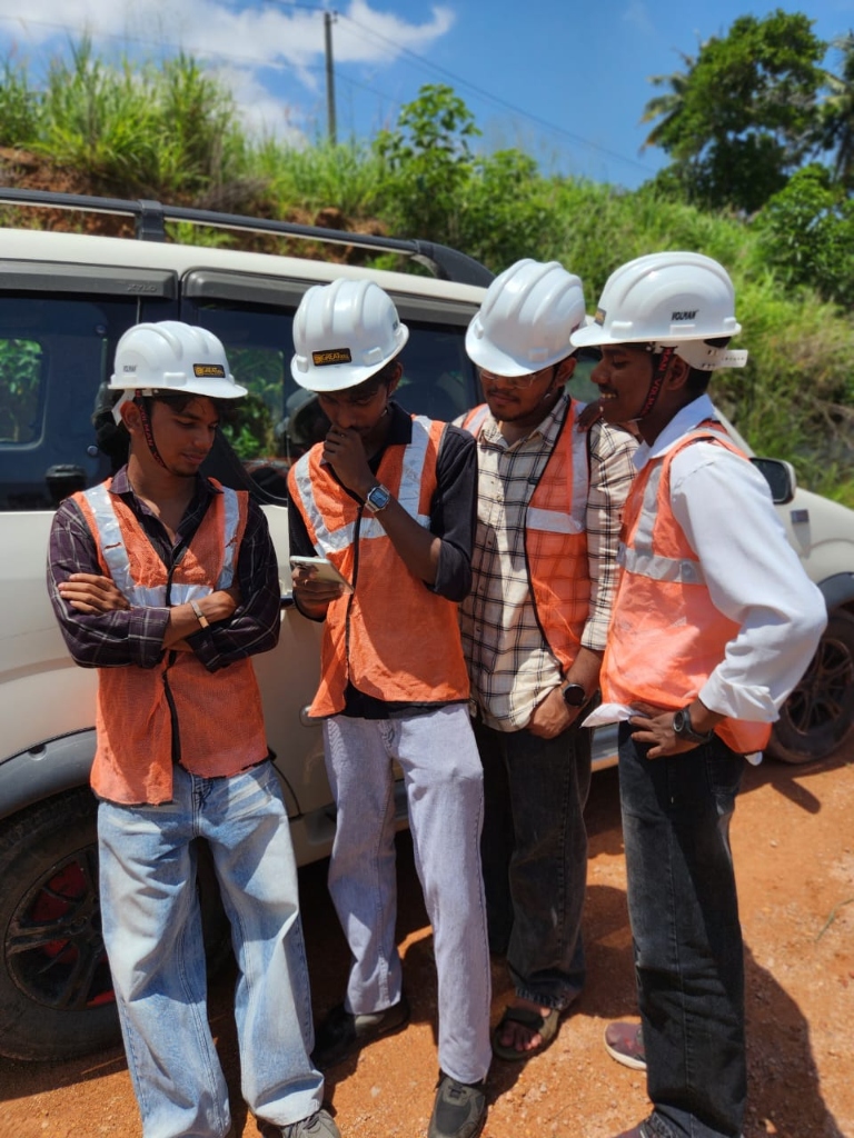 Students in safety vests and hardhats discussing site plans